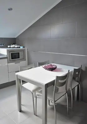 a white table and chairs in a kitchen at Apartamento Vila O Valadouro in O Valadouro