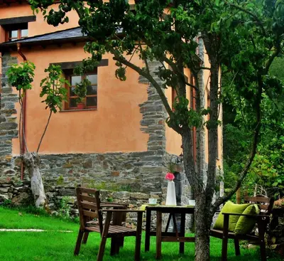 a table and chairs under a tree in front of a building at Apartamentos El Valledor in Tremado
