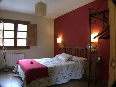 a bedroom with a bed and a red wall at Apartamentos El Valledor in Tremado