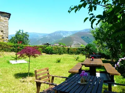 a picnic table in a field with mountains in the background at Apartamentos El Valledor in Tremado