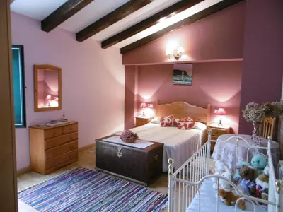 a bedroom with a bed and a dresser and a crib at Casa Benito in Ribadeo