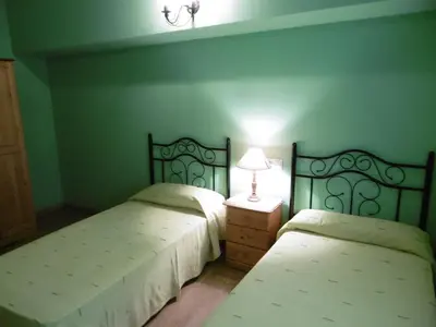 two beds in a room with green walls at Casa Benito in Ribadeo