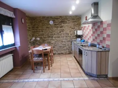 a kitchen with a table and a sink and a counter at Casa Benito in Ribadeo
