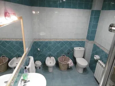 a bathroom with two toilets and a sink and a mirror at Casa Benito in Ribadeo