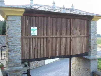 a wooden building with a gate with a sign on it at Casa Benito in Ribadeo