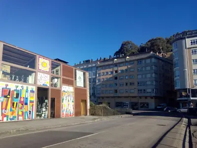 an empty street in a city with tall buildings at Solaina Parking gratuito in Viveiro