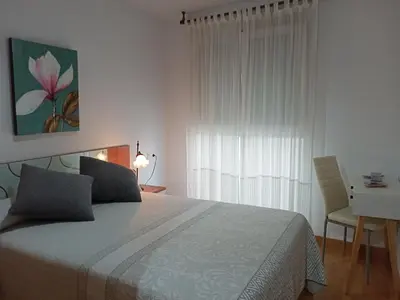 a bedroom with a bed and a desk and a window at Solaina Parking gratuito in Viveiro