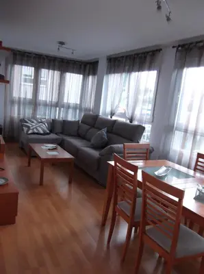 a living room with a couch and tables and windows at Solaina Parking gratuito in Viveiro