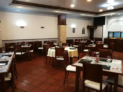 a restaurant with tables and chairs in a room at H. O Lar in O Barco de Valdeorras
