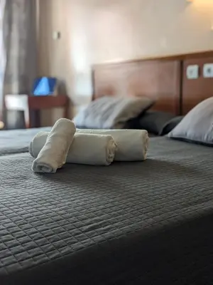 a rolled up towel on top of a bed at H. O Lar in O Barco de Valdeorras