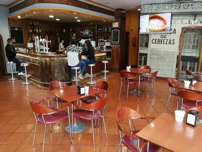 a restaurant with tables and chairs and a bar at H. O Lar in O Barco de Valdeorras