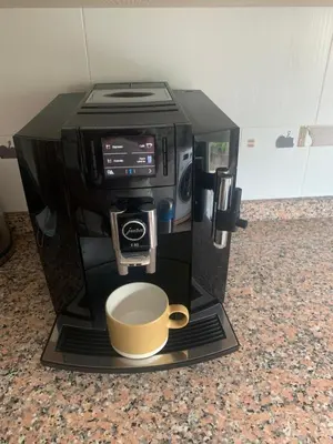 a coffee maker with a cup on a counter at Pilgrim’s House in O Pedrouzo
