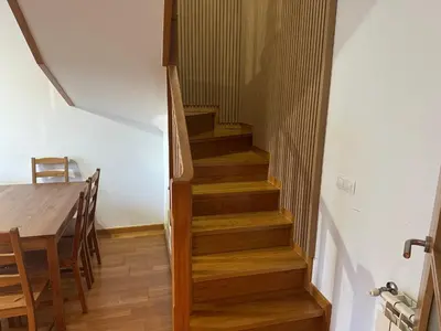 a staircase in a house with a table and a stair case at Pilgrim’s House in O Pedrouzo