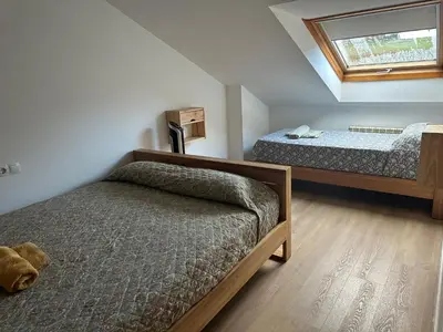 a bedroom with two beds and a window at Pilgrim’s House in O Pedrouzo