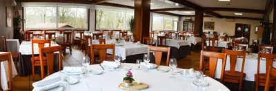 a restaurant with tables and chairs with white table cloth at Hotel Os Caracoles in Pereiro de Aguiar