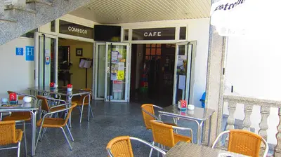 a restaurant with tables and chairs in front of a cafe at Hotel Os Caracoles in Pereiro de Aguiar