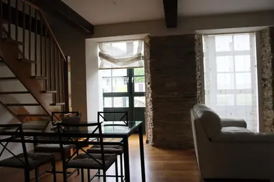 a living room with a staircase and a table and chairs at Casa Pedrosa in Mondoñedo