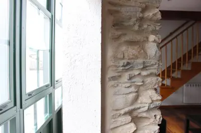 a room with a stone wall and a window at Casa Pedrosa in Mondoñedo