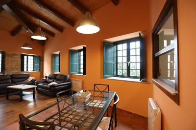 a living room with orange walls and a glass table at Casa Pedrosa in Mondoñedo