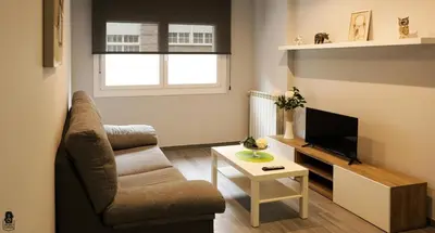 a living room with a chair and a television at dpCristal City Apartments in Sarria