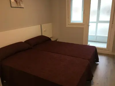 a bedroom with a bed and a window at dpCristal City Apartments in Sarria
