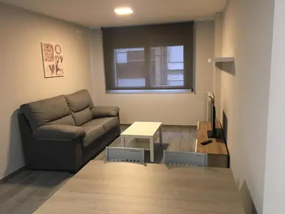 a living room with a couch and a table at dpCristal City Apartments in Sarria