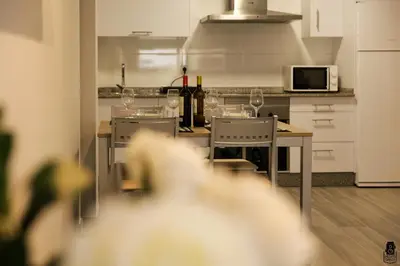 a kitchen with a table with wine glasses on it at dpCristal City Apartments in Sarria