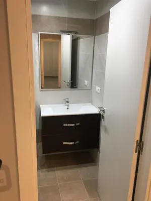 a bathroom with a sink and a mirror at dpCristal City Apartments in Sarria