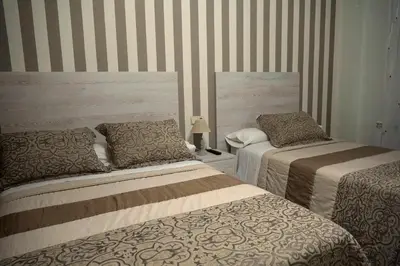 a bedroom with two beds and a striped wall at Rosende in Arzúa