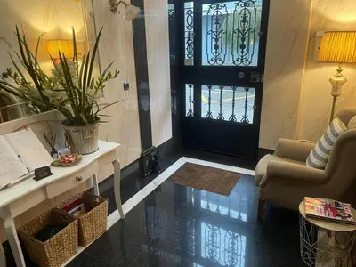a lobby with a black door and a chair and a table at Rosende in Arzúa