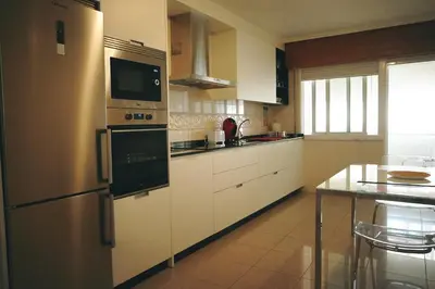 a kitchen with white cabinets and a stainless steel refrigerator at Rosende in Arzúa