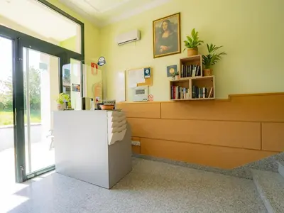 a waiting room with a white refrigerator in a building at Pensión Palas in Palas de Rei
