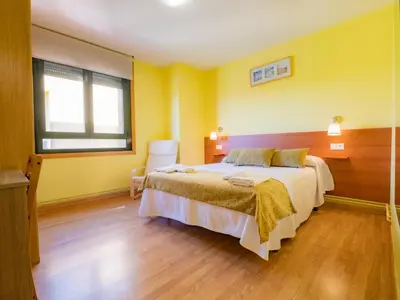 a bedroom with a large bed with yellow walls at Pensión Palas in Palas de Rei