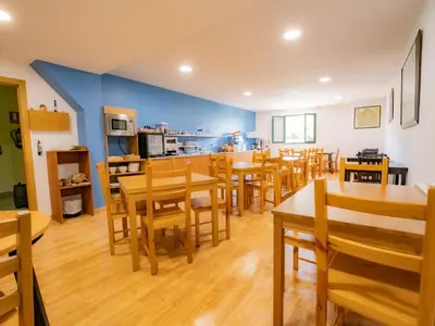 a dining room with wooden tables and chairs at Pensión Palas in Palas de Rei