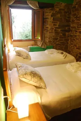 three beds in a room with a window at Isabel Artemis ES in San Tirso de Abres