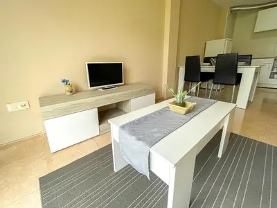 a living room with a table with a tv on it at Alojamientos Playa de las Catedrales 3000 in Barreiros