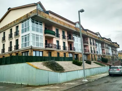 an apartment building with a car parked in front of it at Alojamientos Playa de las Catedrales 3000 in Barreiros
