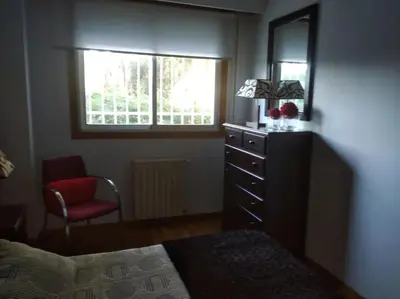 a bedroom with a dresser and a chair and a window at Cozy apartment in Orense of 45 m² with parking in Ourense