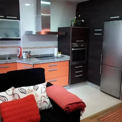 a kitchen with a couch and a kitchen with a refrigerator at Cozy apartment in Orense of 45 m² with parking in Ourense