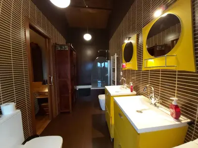 a bathroom with two sinks and a yellow at Apartamentos Rosa Jove in Cabañas
