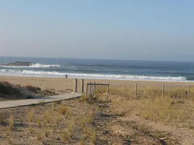 a beach with a volley ball net and the ocean at Apartamentos Rosa Jove in Cabañas