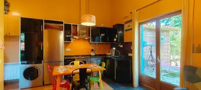 a kitchen with a table and a small table with chairs at Apartamentos Rosa Jove in Cabañas