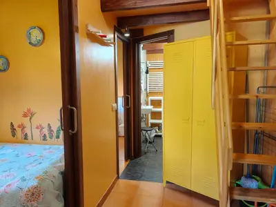 a bedroom with a bed and a yellow door at Apartamentos Rosa Jove in Cabañas