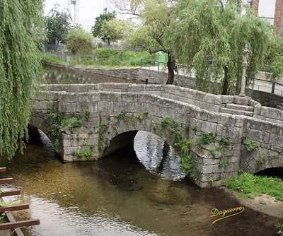 an old stone bridge over a body of water at Apartamento La Iglesia in Caldas de Reis