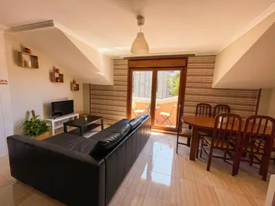 a living room with a black couch and a table at Apartamento La Iglesia in Caldas de Reis