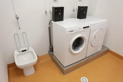 a bathroom with a washing machine and a toilet at Pensión Rúa Peregrino in Sarria