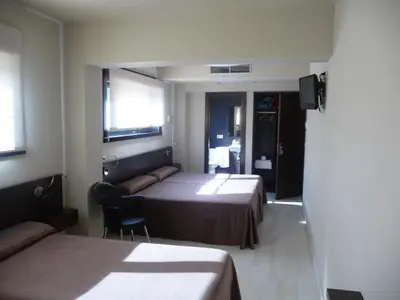 a hotel room with two beds and a television at PENSIÓN RESTAURANTE 