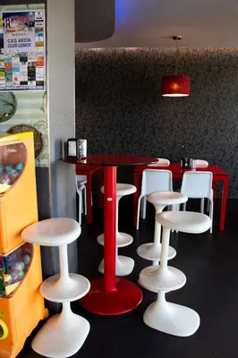 a restaurant with a red table and white stools at PENSIÓN RESTAURANTE 