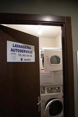a door to a bathroom with a washing machine and a sign at PENSIÓN RESTAURANTE 