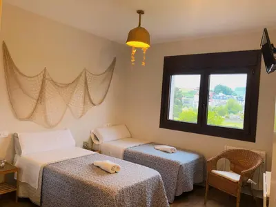 a room with two beds and a window at Villa Galicia in Caldas de Reis